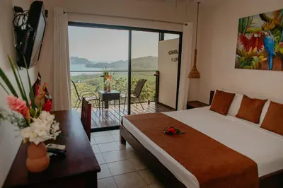 a bedroom with a bed and a balcony with a view at Eco Boutique Hotel Vista Las Islas Reserva Natural in Paquera