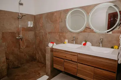 a bathroom with a sink and a large mirror at Eco Boutique Hotel Vista Las Islas Reserva Natural in Paquera