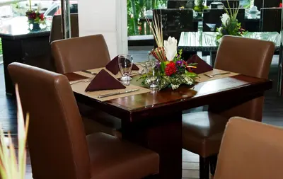 a wooden table with chairs and flowers on it at Rincon del Valle Hotel & Suites in San José