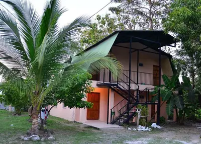 a small house with a staircase in front of it at Mapi's Cabins in Paquera