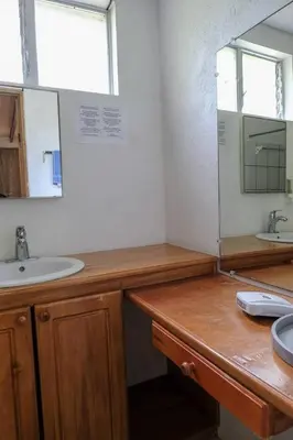 a bathroom with a sink and a mirror at Mapi's Cabins in Paquera