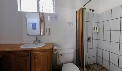 a bathroom with a toilet and a sink and a shower at Mapi's Cabins in Paquera