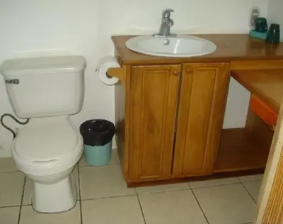 a bathroom with a white toilet and a sink at Mapi's Cabins in Paquera