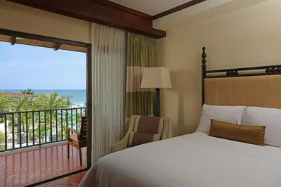 a bedroom with a bed and a balcony with the ocean at JW Marriott Guanacaste Beach Resort in Tamarindo
