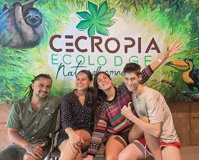 a group of people sitting in front of a sign at Cecropia Ecolodge in Fortuna