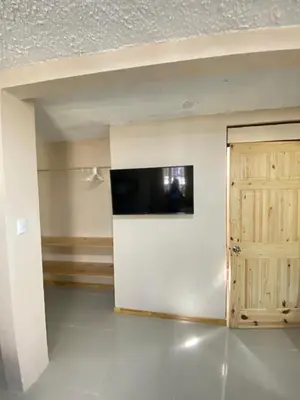a living room with a television and a door at Agutí Apartment in Manuel Antonio