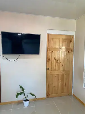 a flat screen tv on a wall next to a door at Agutí Apartment in Manuel Antonio