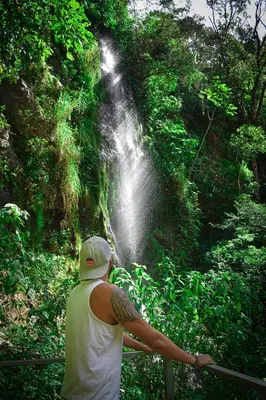 a man standing in front of a waterfall at Valle Escondido Nature Reserve Hotel & Farm in Monteverde Costa Rica