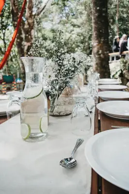 a table with a glass vase with lime slices in it at Valle Escondido Nature Reserve Hotel & Farm in Monteverde Costa Rica