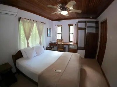 a bedroom with a large bed with a ceiling fan at Casa Cecilia Beach Front in Santa Teresa Beach