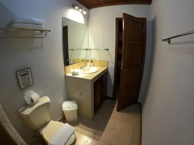 a bathroom with a toilet and a sink and a mirror at Casa Cecilia Beach Front in Santa Teresa Beach