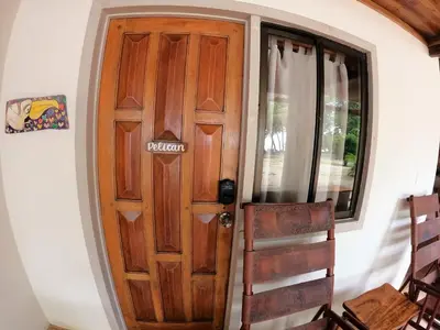 a wooden door in a room with two chairs at Casa Cecilia Beach Front in Santa Teresa Beach