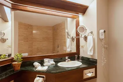 a bathroom with a sink and a large mirror at Wyndham San Jose Herradura in San José