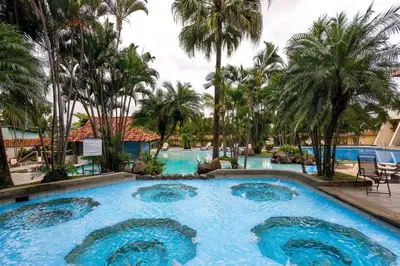 a pool at a resort with palm trees at Wyndham San Jose Herradura in San José