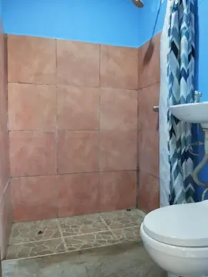 a bathroom with a toilet and a shower at Chill-Inn Nosara in Nosara
