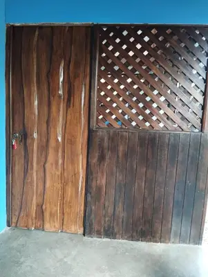 a wooden garage door with a gate in a room at Chill-Inn Nosara in Nosara