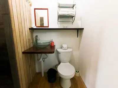 a bathroom with a toilet with a sink and a mirror at Chill-Inn Nosara in Nosara