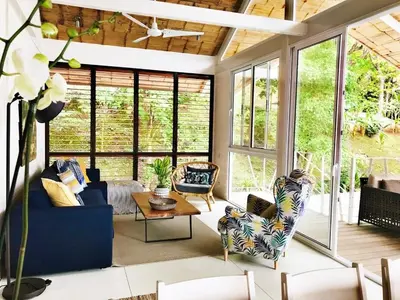 a living room with a blue couch and chairs at marAmar Bungalows by STH in Santa Teresa Beach