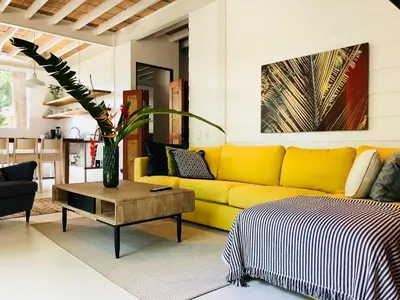 a yellow couch in a living room with a table at marAmar Bungalows by STH in Santa Teresa Beach