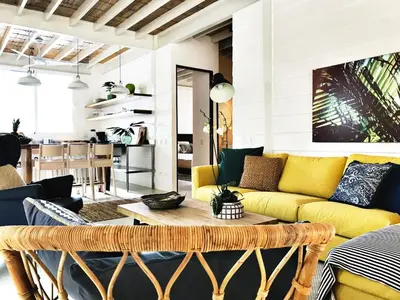 a living room with a yellow couch and a table at marAmar Bungalows by STH in Santa Teresa Beach