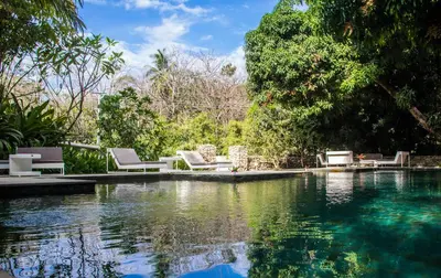 a swimming pool with lounge chairs next to the water at marAmar Bungalows by STH in Santa Teresa Beach
