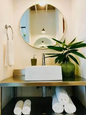 a bathroom with a sink and a mirror and towels at marAmar Bungalows by STH in Santa Teresa Beach