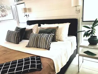 a bed with pillows on it in a room at marAmar Bungalows by STH in Santa Teresa Beach