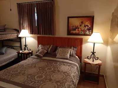 a small bedroom with a bed and two lamps at Marita's Bed and Breakfast in Nuevo Arenal