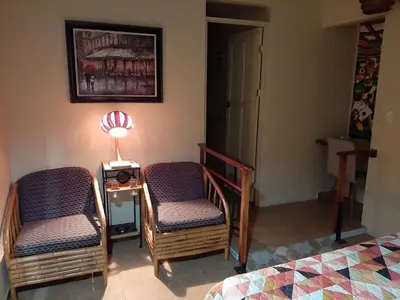 a room with two chairs and a table and a bed at Marita's Bed and Breakfast in Nuevo Arenal