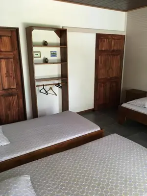 a bedroom with two beds and wooden cabinets at Casa Taupe in Carrillo