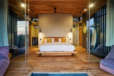 a bedroom with a bed and a pool at SELVA RESORT Ocean View Luxury Villas in Santa Teresa Beach