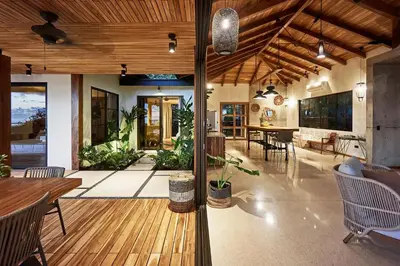 a large living room with a wooden floor and a dining room at SELVA RESORT Ocean View Luxury Villas in Santa Teresa Beach