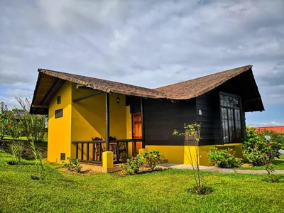 a small yellow house with a black roof at Hotel Campo Verde in Fortuna