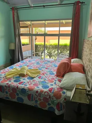 a bedroom with a bed with a colorful quilt on it at Villas Paraíso Jacó B20 in Jacó