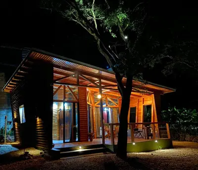 a house with a tree in front of it at night at Hoja Azul in Hojancha