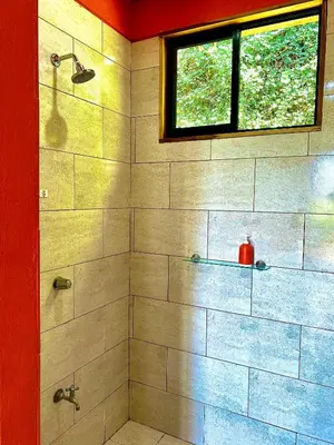a bathroom with a shower with a window at Hoja Azul in Hojancha