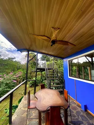 a porch with a table and a ceiling fan at Natural Wonders House in Monteverde Costa Rica