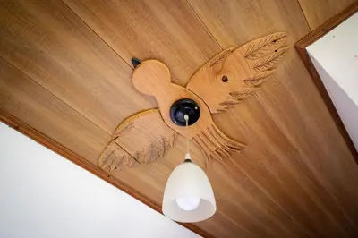 a ceiling light with a wooden bird design on it at Natural Wonders House in Monteverde Costa Rica