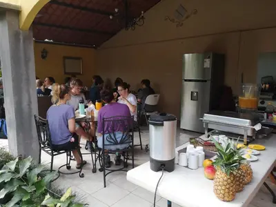a group of people sitting at tables in a kitchen at Hotel Santa Maria Inn in Alajuela City