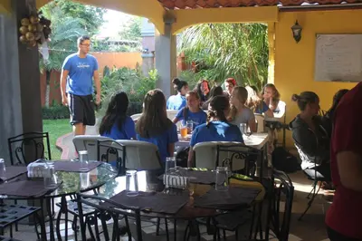 a group of people sitting at tables in a restaurant at Hotel Santa Maria Inn in Alajuela City