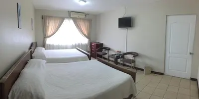 a bedroom with two beds and a window at Hotel Santa Maria Inn in Alajuela City