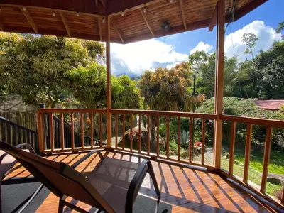 a screened in porch with two chairs and a view of trees at Jardines Secretos in Rivas