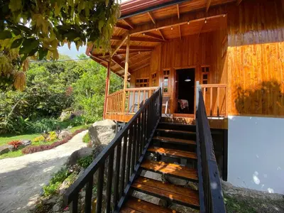 a wooden house with stairs leading to a door at Jardines Secretos in Rivas