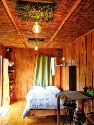 a bedroom with a bed in a wooden room at Cabaña Mountain View in Heredia