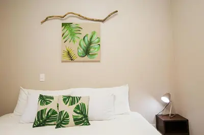a bedroom with a bed with green leaves on the wall at Apartamento Lantana ,Monteverde con Aire Acondicionado y Lavanderia in Monteverde Costa Rica
