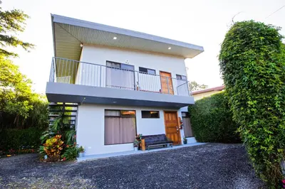 a white house with a balcony and a porch at Apartamento Lantana ,Monteverde con Aire Acondicionado y Lavanderia in Monteverde Costa Rica