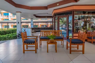 a restaurant with wooden chairs and a table with a plant at Best Western Jaco Beach All Inclusive Resort in Jacó