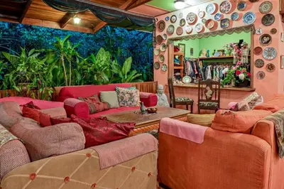 a living room with red couches and a mirror at Lands in Love Hotel and Resort in Colonia Palmareña