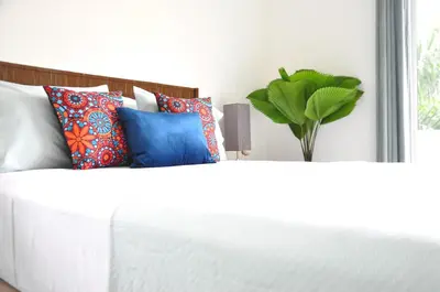 a white bed with a bunch of pillows on it at Pazifico Villas in Playa Avellana