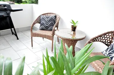 a patio with two chairs and a table with a plant at Pazifico Villas in Playa Avellana